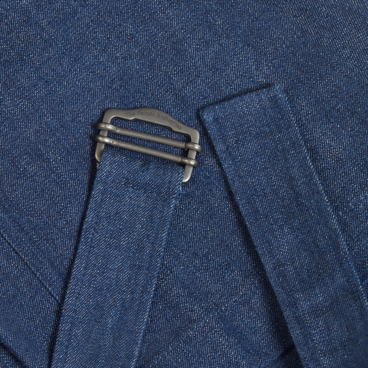 Close-up of denim jeans belt detail with metal clasp engraved with brand name The Female Archetypes.