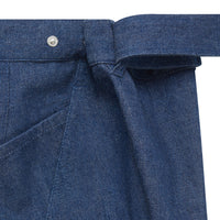 Close-up of dark blue women's jeans with adjustable waistband featuring a button and belt detail.