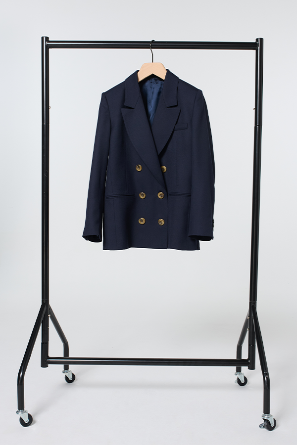 Navy blue blazer with gold buttons, hanging on a wooden hanger against a black metal clothing rack.